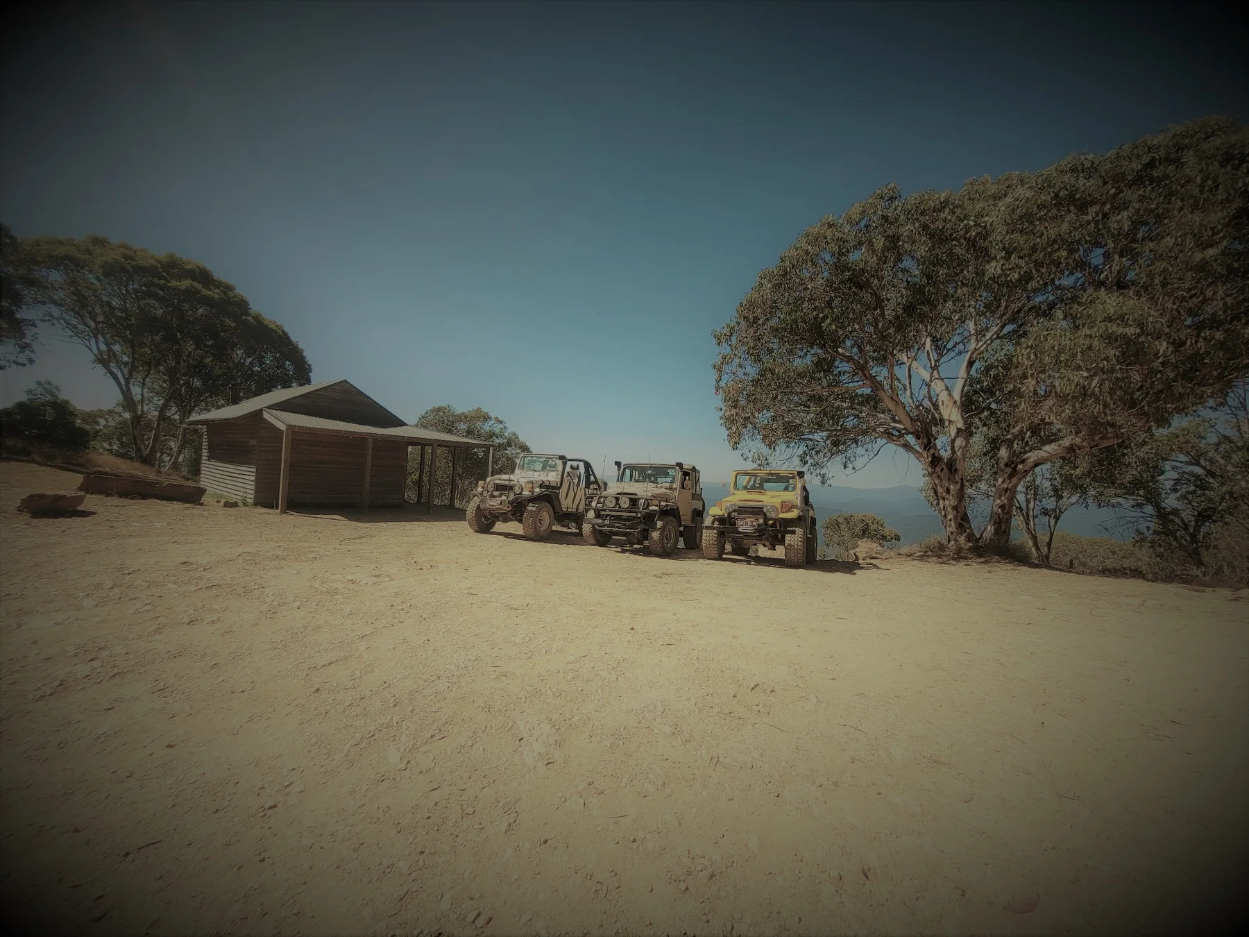 Classic LandCruisers on a ridge in vintage tones